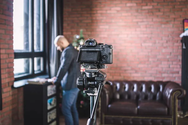 Man blogger prepares to record himself on video blog on the camera in studio — Stock Photo, Image