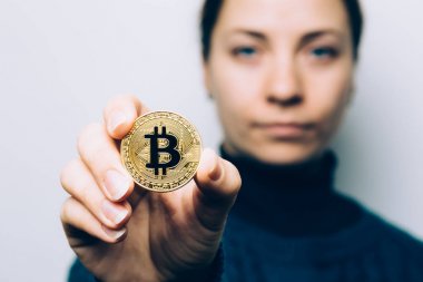 Genç kadın altın Bitcoin para - cryptocurrency, yeni sanal para, seçici odak sembolü gösterir