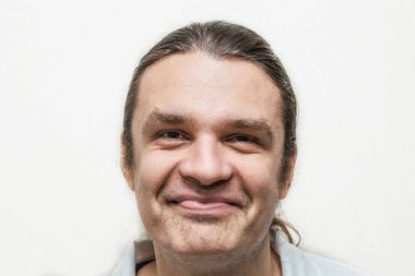 Komik gülümseyen adam kameraya beyaz arka plan üzerinde seyir