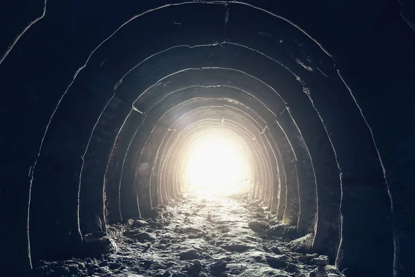 Luz al final del túnel industrial oscuro, cueva subterránea abandonada o mina, salida o escape al concepto de luz de libertad — Foto de Stock