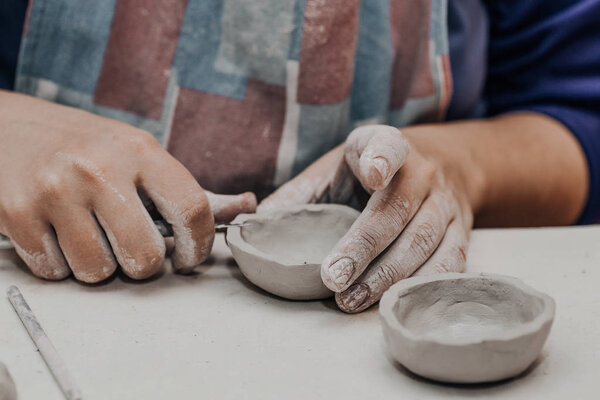 Female potter works with clay, craftsman hands close up