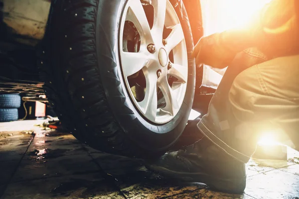 Balanceamento de rodas ou reparação e mudança de pneu de carro na garagem ou oficina de serviço de automóvel por mecânico — Fotografia de Stock