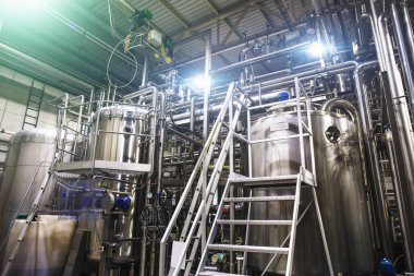 Paslanmaz çelik ekipman bira: büyük rezervuarlar veya tank ve boru modern bira fabrikasında. Bira üretimi, endüstriyel arka plan