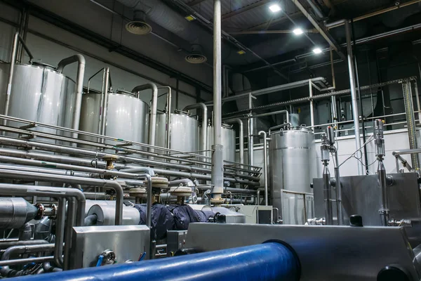 Equipo cervecero de acero inoxidable: grandes depósitos o tanques y tuberías en la fábrica de cerveza moderna. Producción cervecera, antecedentes industriales — Foto de Stock
