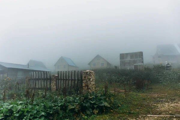 Campagne de montagne avec petites maisons et brouillard le matin brouillard ou brouillard — Photo