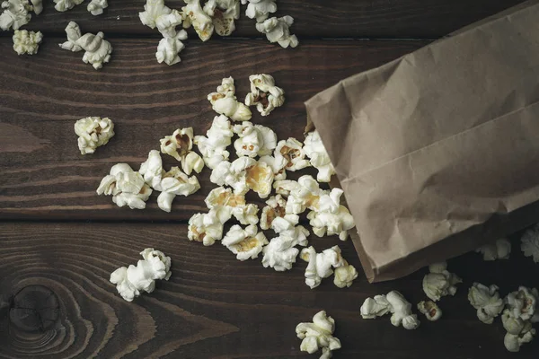 Popcorn in paper bag on table, top view — Stock Photo, Image