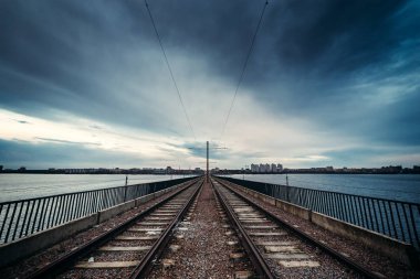 Demiryolu yol dramatik bulutlu mavi gökyüzü arka plan üzerinde şehir, bakış açısı ile köprü aracılığıyla