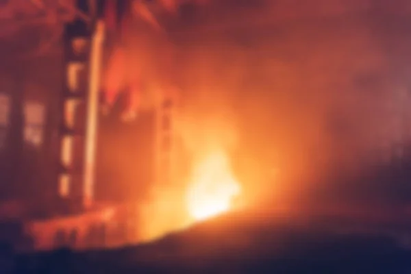 Onscherpe achtergrond van brand in interieur van industriële fabriek, abstracte intreepupil branden gebouw binnen bij nacht — Stockfoto