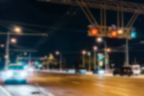 Blurred city street with cars at night, defocused urban background