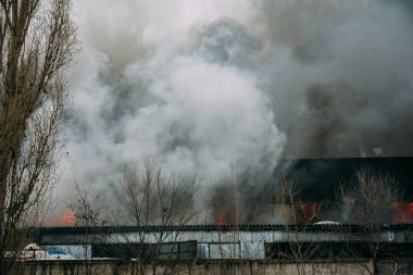 Bir endüstriyel depo veya fabrika, çok duman ve alevler ateş