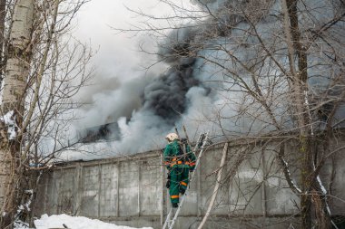 Bir endüstriyel depo veya fabrika, çok duman ve alevler ateş