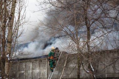 Bir endüstriyel depo veya fabrika, çok duman ve alevler ateş