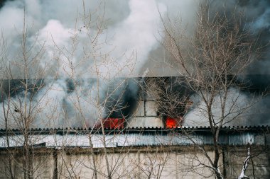 Bir endüstriyel depo veya fabrika, çok duman ve alevler ateş