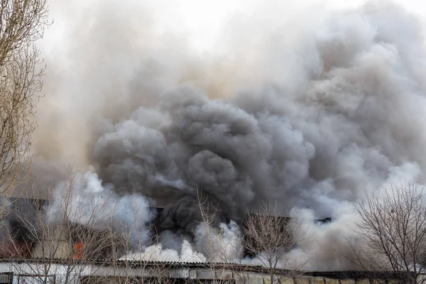 Incêndio em um armazém industrial ou fábrica, muita fumaça e chamas — Fotografia de Stock