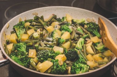Demlenmiş tavada sebze: brokoli, yeşil fasulye, patates, soğan ve baharat. Vejetaryen Gıda
