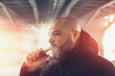 Vape adam. Vaping elektronik sigara veya vape kalem kentsel arka plan, modern yaşam kavramı, genç adam