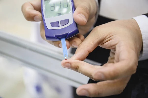 Glucosímetro: dispositivo médico. El hombre comprueba el nivel de azúcar en sangre por sangre del dedo, enfermedad diabética —  Fotos de Stock