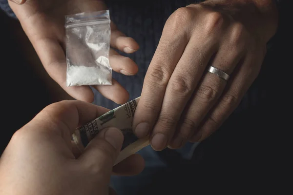 Наркоман с деньгами покупает дозу кокаина или героина или другого наркотика у наркодилера. Наркомания и дорожное движение — стоковое фото