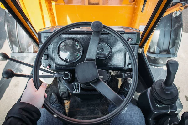 Driver in modern tractor or excavator cabin, view from driver eye position