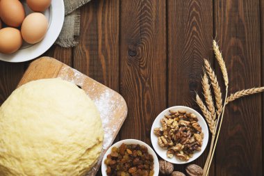 Fırın arka plan, pişirme kek malzemeler: yumurta, un, ceviz ve kuru üzüm üzerinde ahşap masa, üstten görünüm