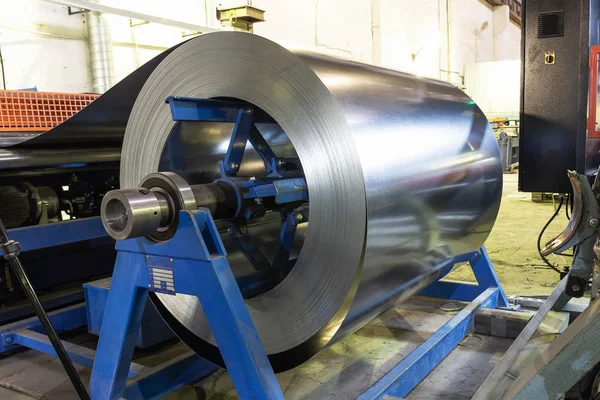 Rollo de chapa de acero galvanizado en la máquina de corte, ferretería y fábrica de fabricación de metalurgia, producción de tubos y tubos metálicos — Foto de Stock