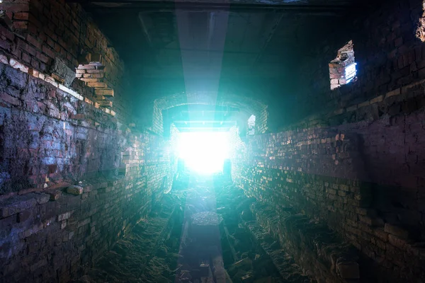 Темний тунель або підземний коридор зі світлом в кінці кінців, надія на свободу і вихід на концепцію світла — стокове фото