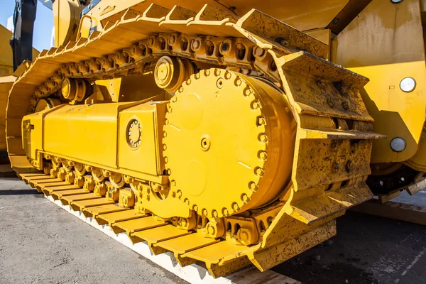 Modern bulldozer tracks and drive gear, large yellow construction machine, heavy industry