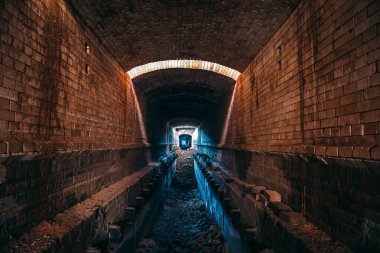 Uzun metro tuğla tünel veya endüstriyel koridor, ürpertici ve korku atmosferi, perspektif