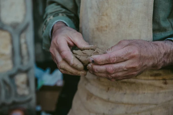 Potter arbeider med leire, håndverkerhender tett inntil, kneledd og fuktig leire – stockfoto