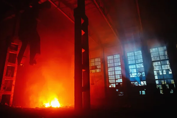 Incêndio noturno dentro de uma grande oficina de uma fábrica industrial ou armazém, um seguro de acidentes industriais — Fotografia de Stock