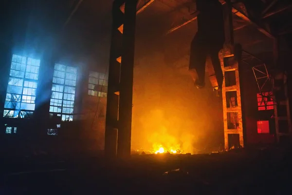 밤에 공장 이나 창 고의 대형 홀에서 화재. 빨간색과 노란색 화재와 윈도에서 파란 빛의 거 대 한 불꽃. 구운된 산업 건물에 재해 — 스톡 사진