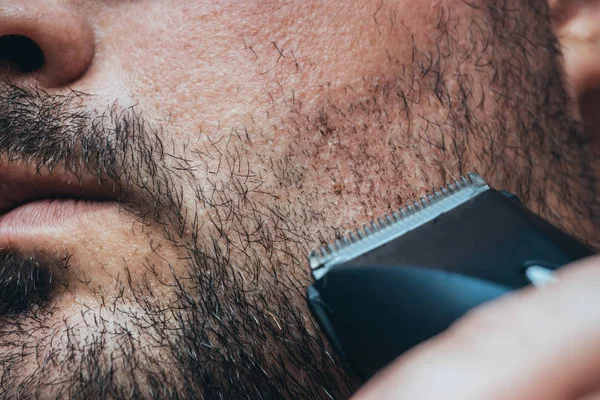 Homme rasant sa chevelure avec une tondeuse à cheveux ou une tondeuse électrique. Soins de la barbe et salon de coiffure — Photo