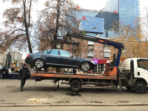 Воронеж, Россия - Примерно в ноябре 2017 года: эвакуатор принимает неправильно припаркованный автомобиль в центре города — стоковое фото