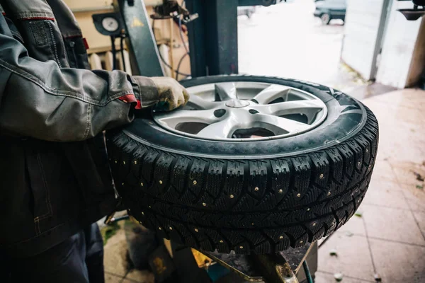 Trabajador mecánico de automóviles haciendo reemplazo de neumáticos y equilibrado de ruedas con equipo especial en la estación de servicio de reparación —  Fotos de Stock