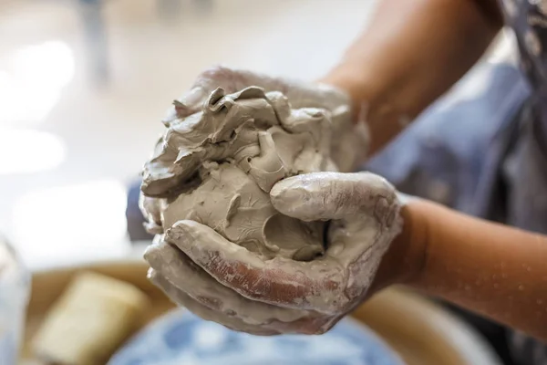 Female potter hands knead wet white clay — Stock Photo, Image