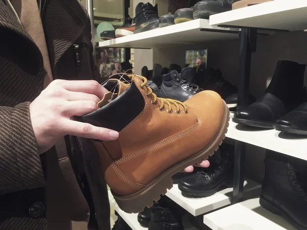 Anak muda membeli atau memilih sepatu musim dingin di toko sepatu — Stok Foto
