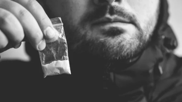 Traficante de drogas oferece dose de cocaína ou outra droga em saco plástico, dependência de drogas no conceito de festa, foco seletivo — Fotografia de Stock