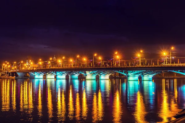Abend voronezh Stadt, Russland. beleuchtete Tschernawsky Brücke mit Reflexionen im Wasser auf woronesch Wasserreservoir in der Nacht — Stockfoto