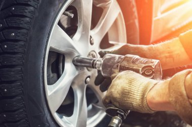 Araba mekanik çalışan onarım servis istasyonu garajında pnömatik anahtar ile lastik veya tekerlek yerine yapıyor