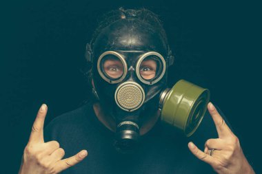 Deli ile gaz maskeli adam yapma rock işareti her iki eliyle gözleri.