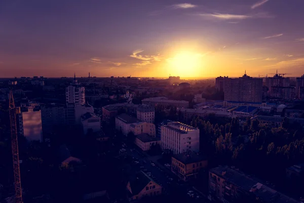 Puesta de sol púrpura sobre la ciudad, iluminación dramática del paisaje urbano, vista desde el techo — Foto de Stock