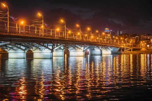 Noche de la ciudad de Voronezh, Rusia. Puente Chernavsky iluminado con reflejos en el agua en el depósito de agua Voronezh por la noche — Foto de Stock