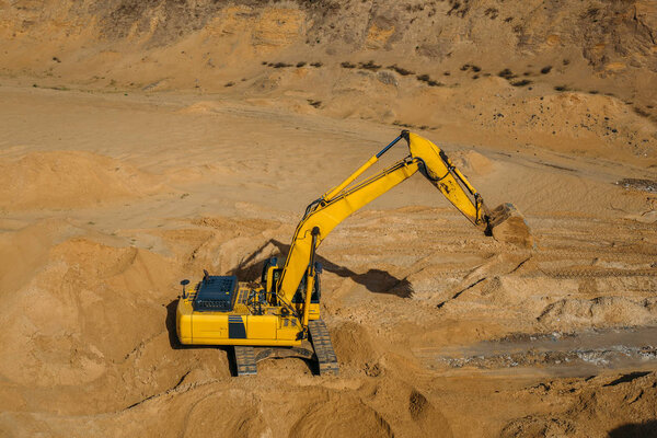 Excavator loader in sand mining quarry, view from above