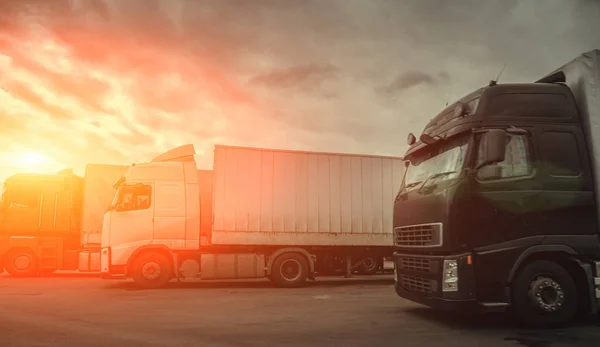 Conceito de logística de negócios, frete Semi Caminhões para transporte de carga e entrega de mercadorias ao pôr do sol, foto panorâmica — Fotografia de Stock