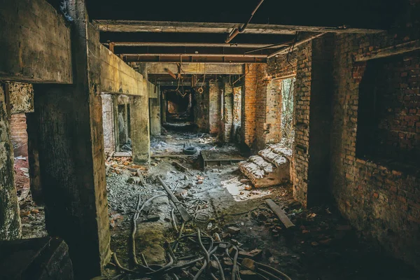 Ruins of industrial building interior after disaster or war or earthquake. Dark creepy tunnel or corridor, horror atmosphere, toned — Stock Photo, Image