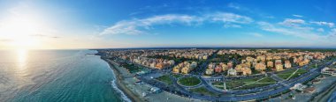 İHA 'dan Ostia plajı panoramik görüntüsü. Ostia Lido Roma, İtalya yakınlarında. Güzel deniz, sahil ve şehir yukarıdan gün batımına bakıyor.