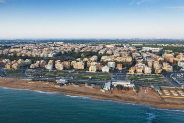 İHA 'dan Ostia plajı hava görüntüsü. Ostia Lido Roma, İtalya yakınlarında. Güzel deniz, sahil ve şehir yukarıdan gün batımına bakıyor.