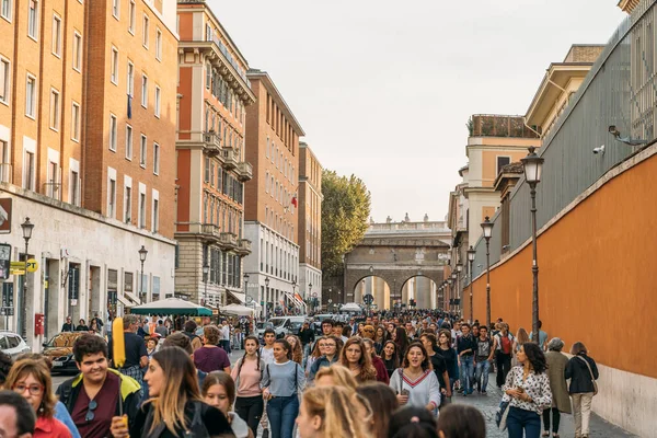 Roma, Italia - circa octubre, 2019: Multitud de turistas en la calle cerca de la puerta del Vaticano y la plaza de San Pietro en Roma, Italia — Foto de Stock