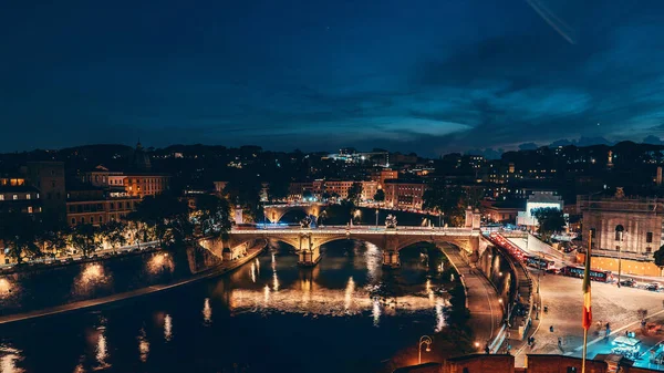 Puente de San Ángel o Ponte Sant Angelo o puente eliano sobre el río Tíber por la noche con iluminación de la ciudad en Roma, Italia, vista desde arriba — Foto de Stock