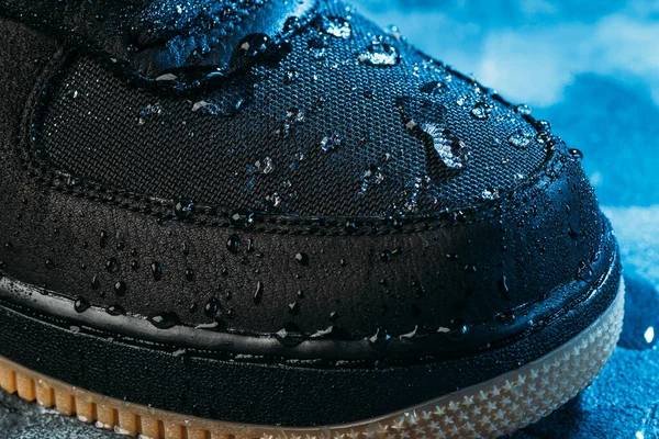 Water druppels op waterdichte membraan weefsel van schoenen oppervlak, macro shot. Nieuwe waterafstotende technologie voor slijtage en schoeisel voor een actieve levensstijl — Stockfoto